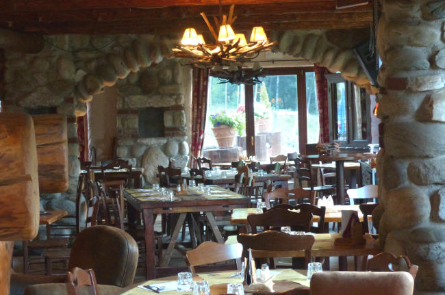 Indoor view of a cafe, with rustic wood and earth bricks.